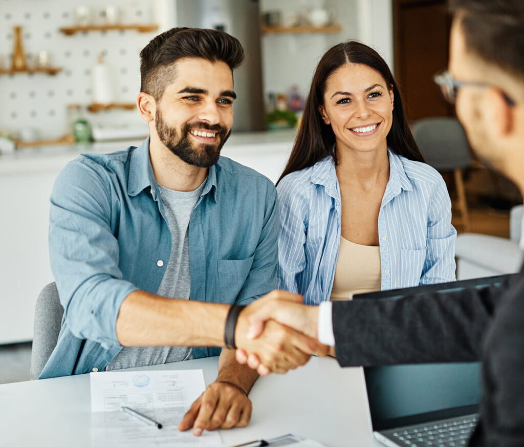 happy couple meets with insurance agent