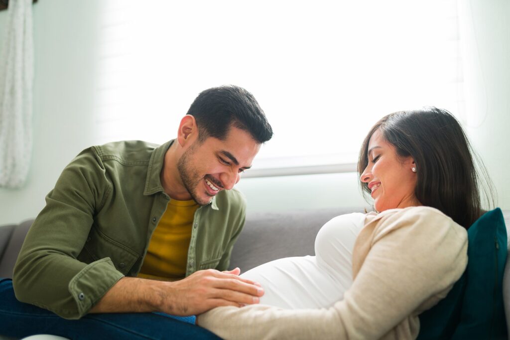 proud father touching pregnant mother's belly