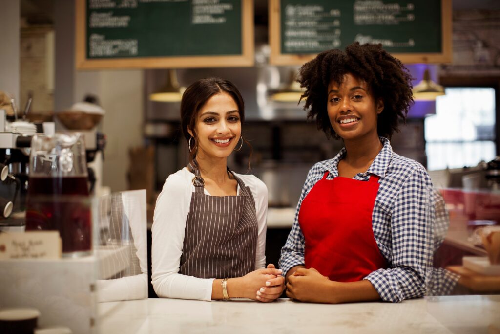 young business owners pose behind the counter at a local coffee shop