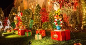 Close-up of a home with festive holiday lights and light-up lawn decorations, highlighting safety tips to prevent fire and liability risks.