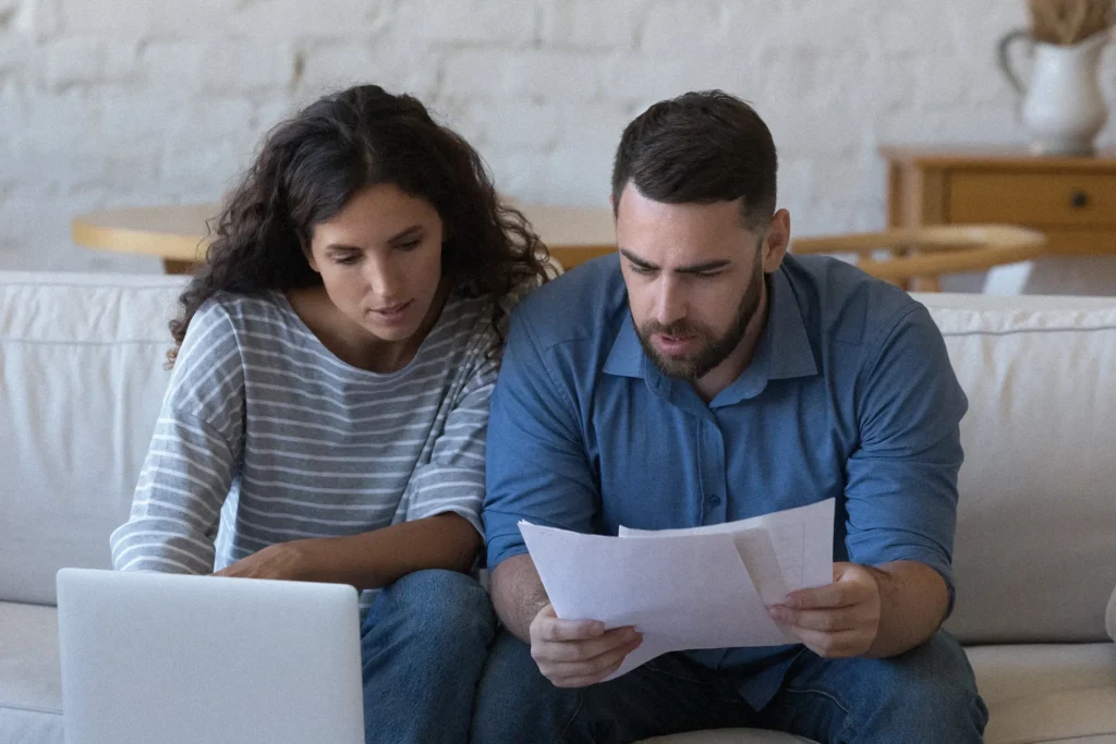 Married couple reviewing homeowners insurance documents together at their kitchen table.