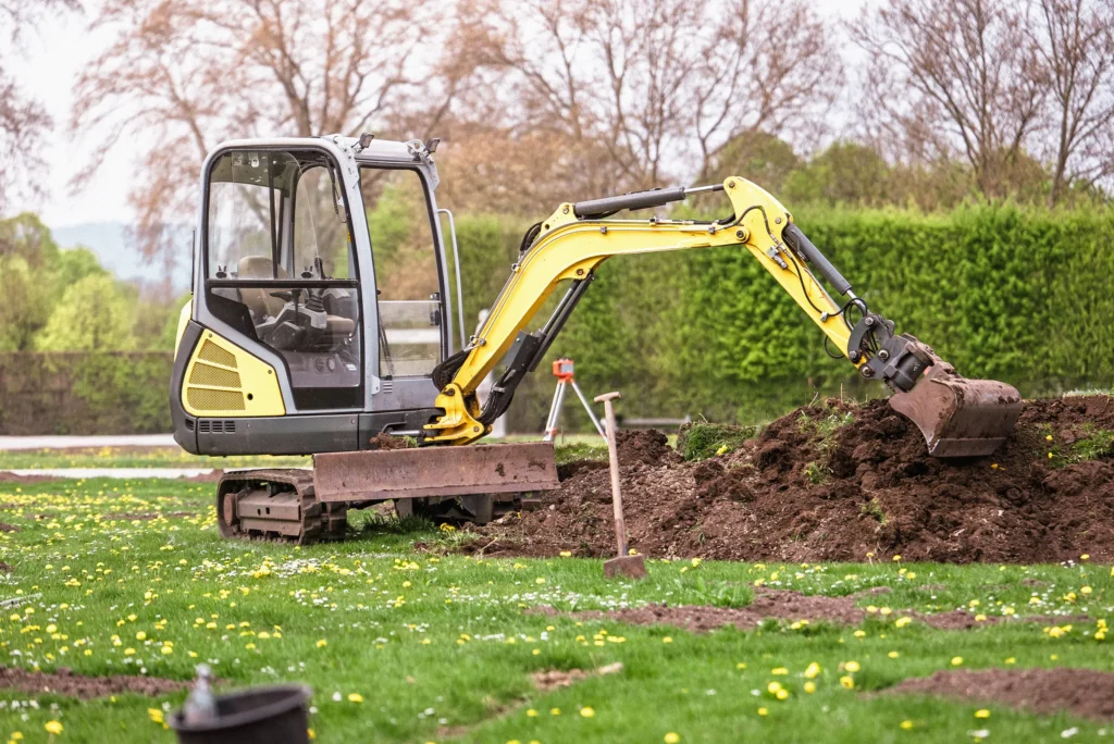 Small excavator digging a trench to repair an underground water service line at a residential property.