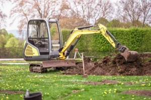 Small excavator digging a trench to repair an underground water service line at a residential property.